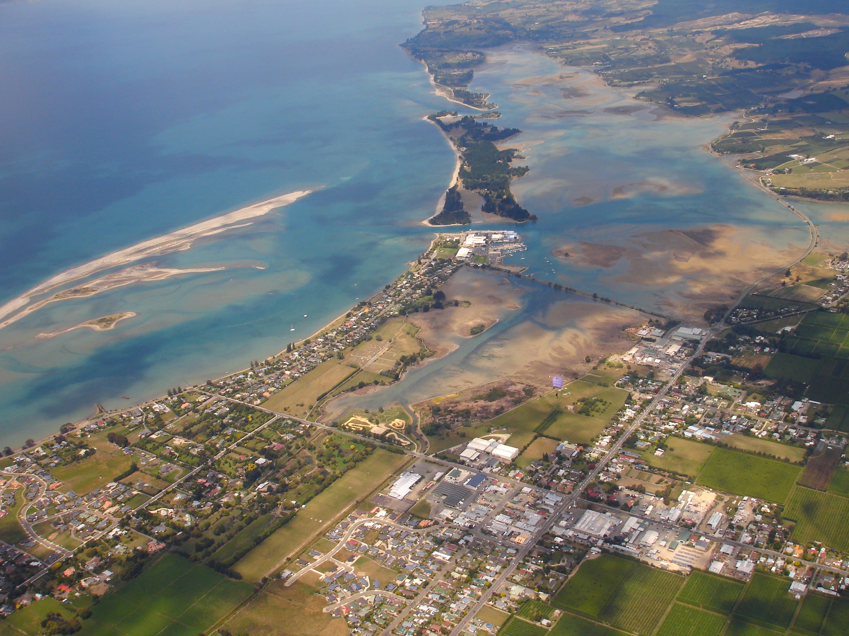 Aerial view of coastal settlements and shallow bays in the upper South Island